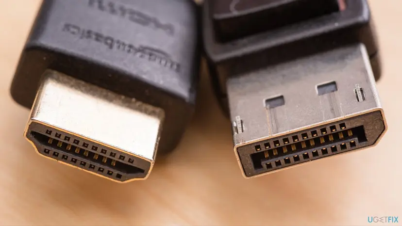 Close-up of an HDMI plug on the left and a DisplayPort plug with its latch on the right, showing the two cable types side by side
